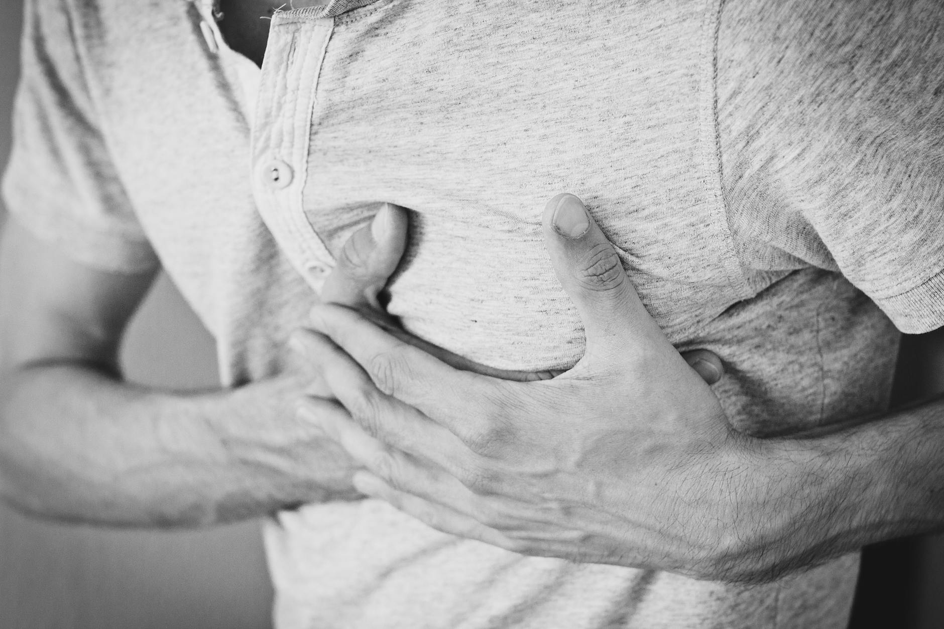 man wearing polo shirt holding left chest