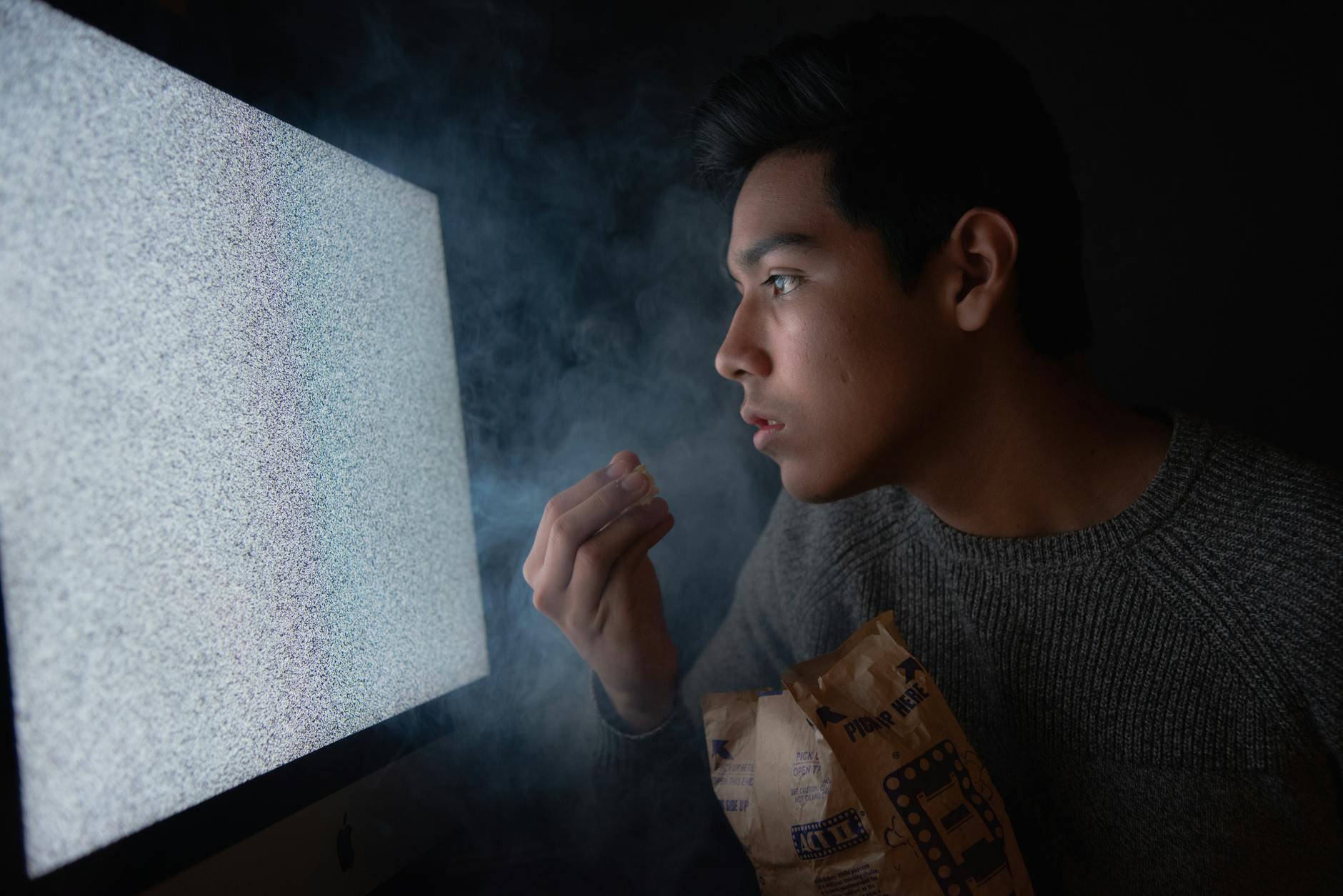 man eating chips while watching tv