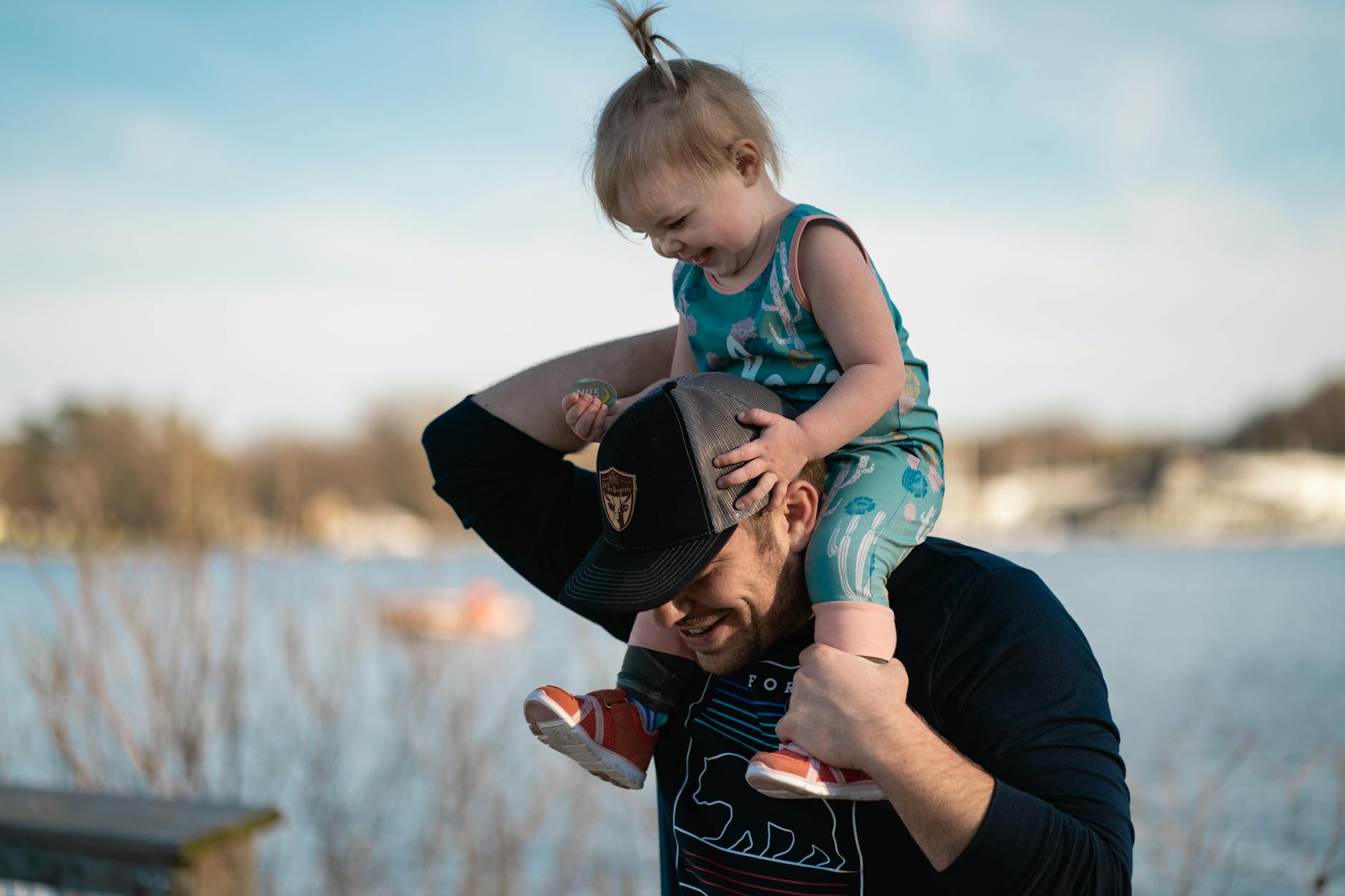 smiling man carrying baby on his neck