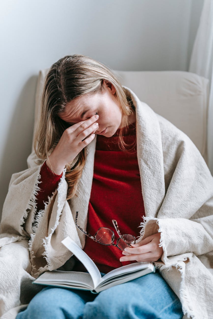 a woman rubbing her eyes with her hand