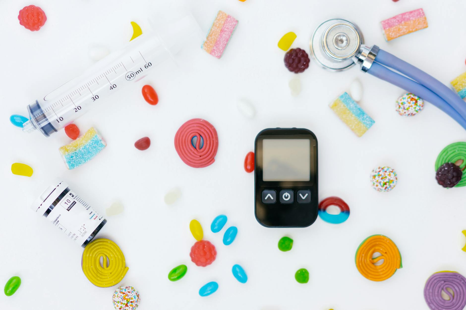 a glucometer and medication lying among scattered sweets